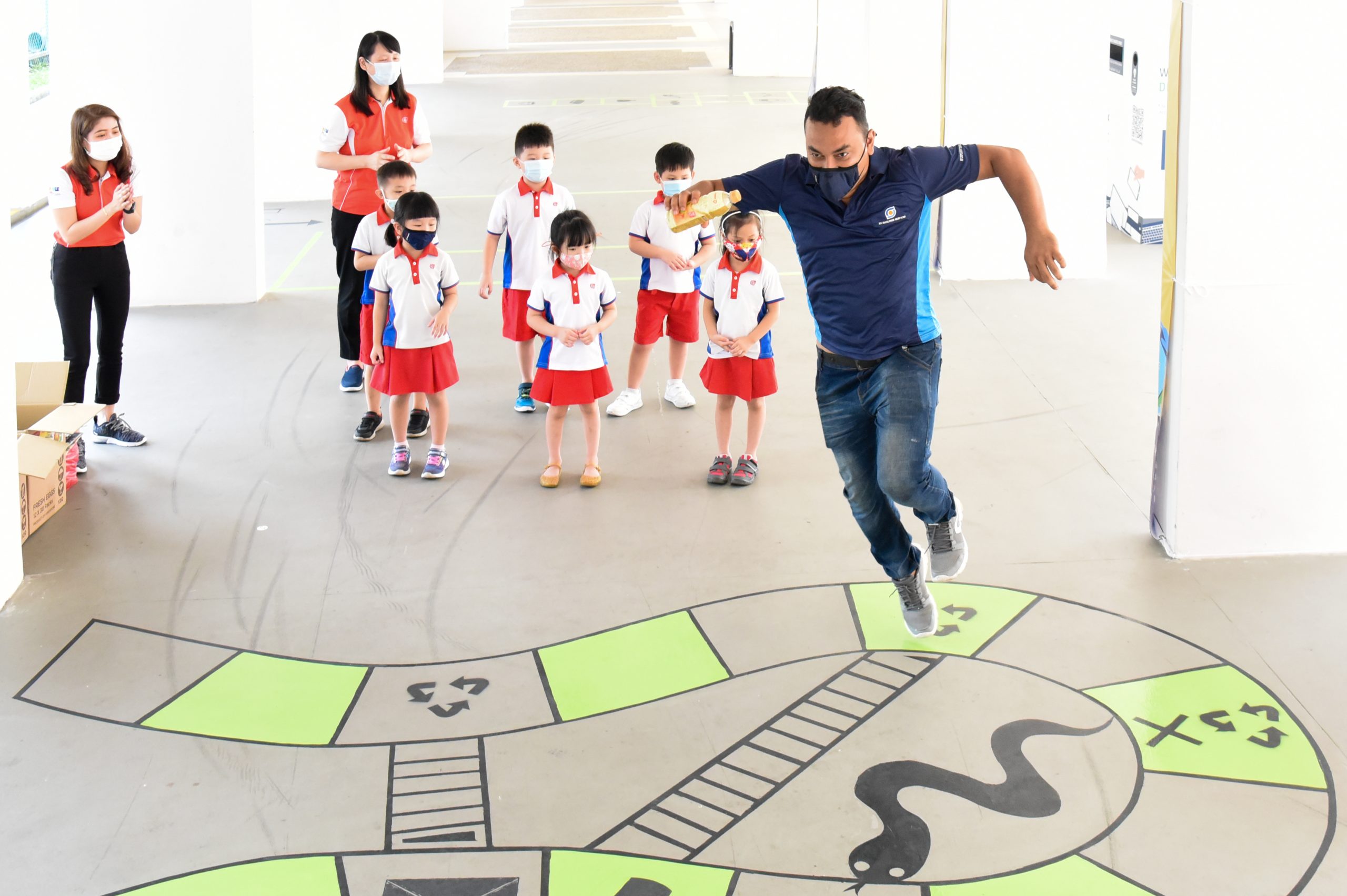 Uncle Islam playing snakes and ladders with the PCF pre-schoolers.