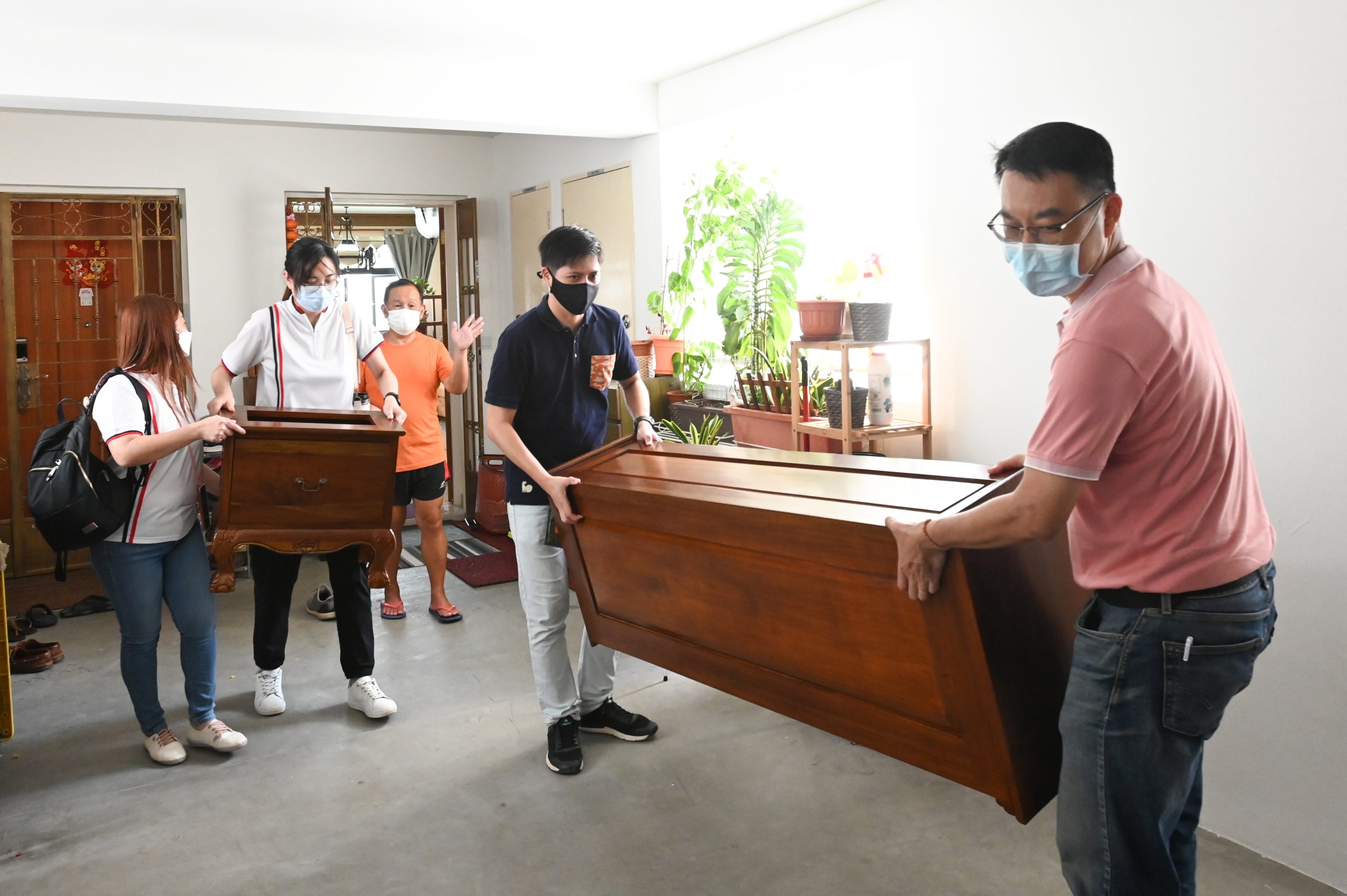 Brickland resident Eric Choong (dressed in orange tee and shorts) donated his mahogany cabinet, which was moved with the help of fellow residents. The volunteer movers are (from left) Toh Ai Tin, Ong Liping, Seph Tan and Tan Chin Tee.