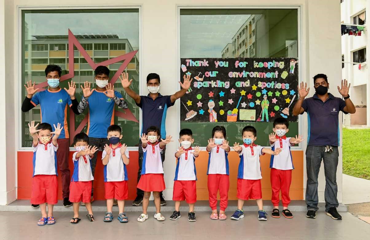 Giving high-fives in the air are the cleaners and kids of Blk 19 Teck Whye Lane.