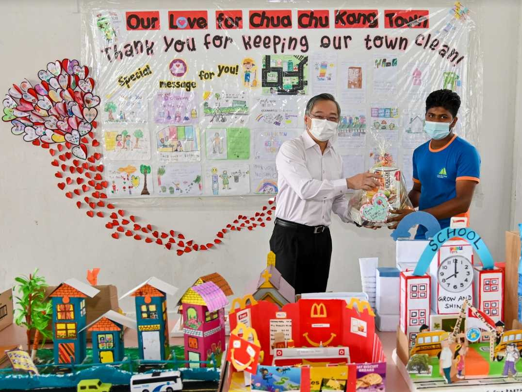 MP for CCK Minister Gan Kim Yong presenting a hamper to Cleaner Islam Saidul at Blk 10’s mini-exhibition event.
