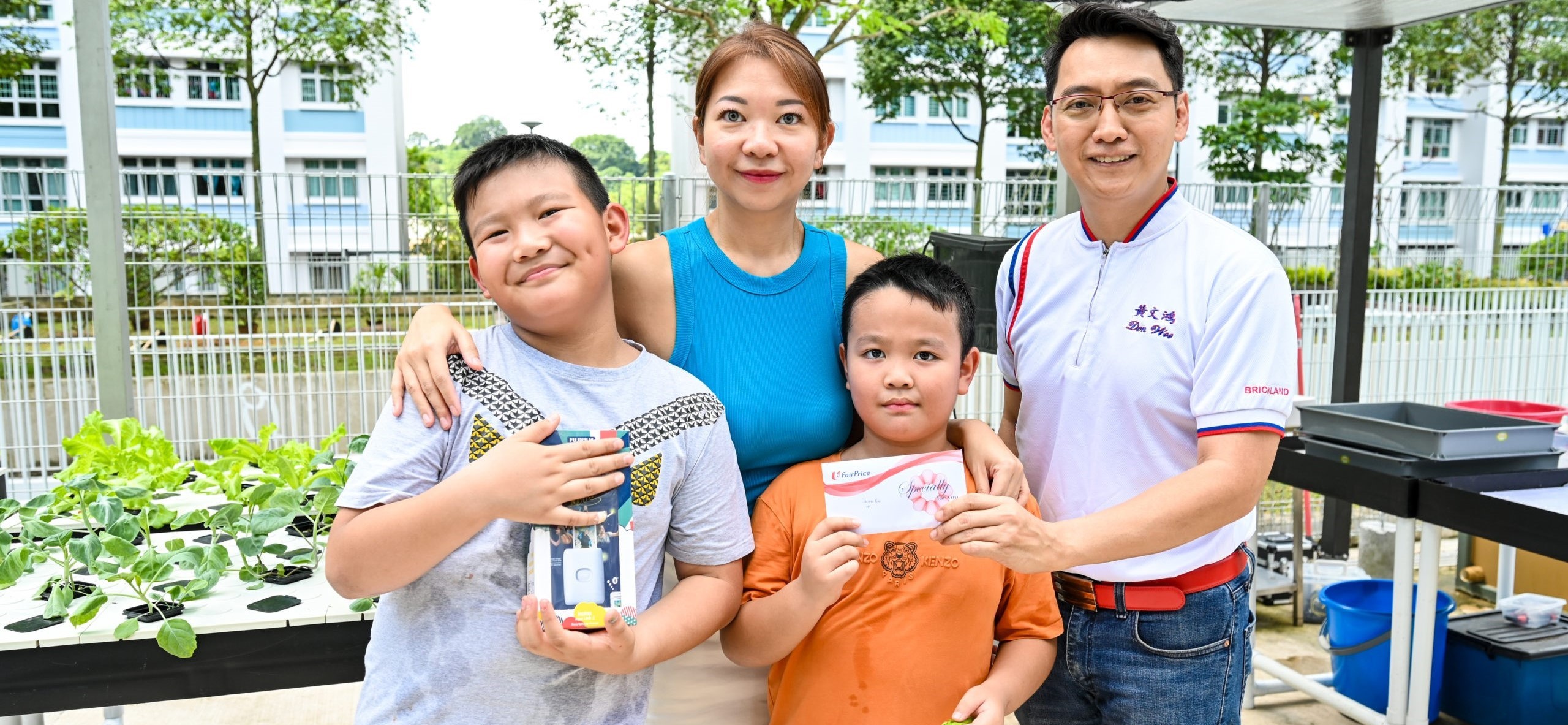 Julien, with her sons Rico and Rayden, receiving her prize from Brickland MP Don Wee.