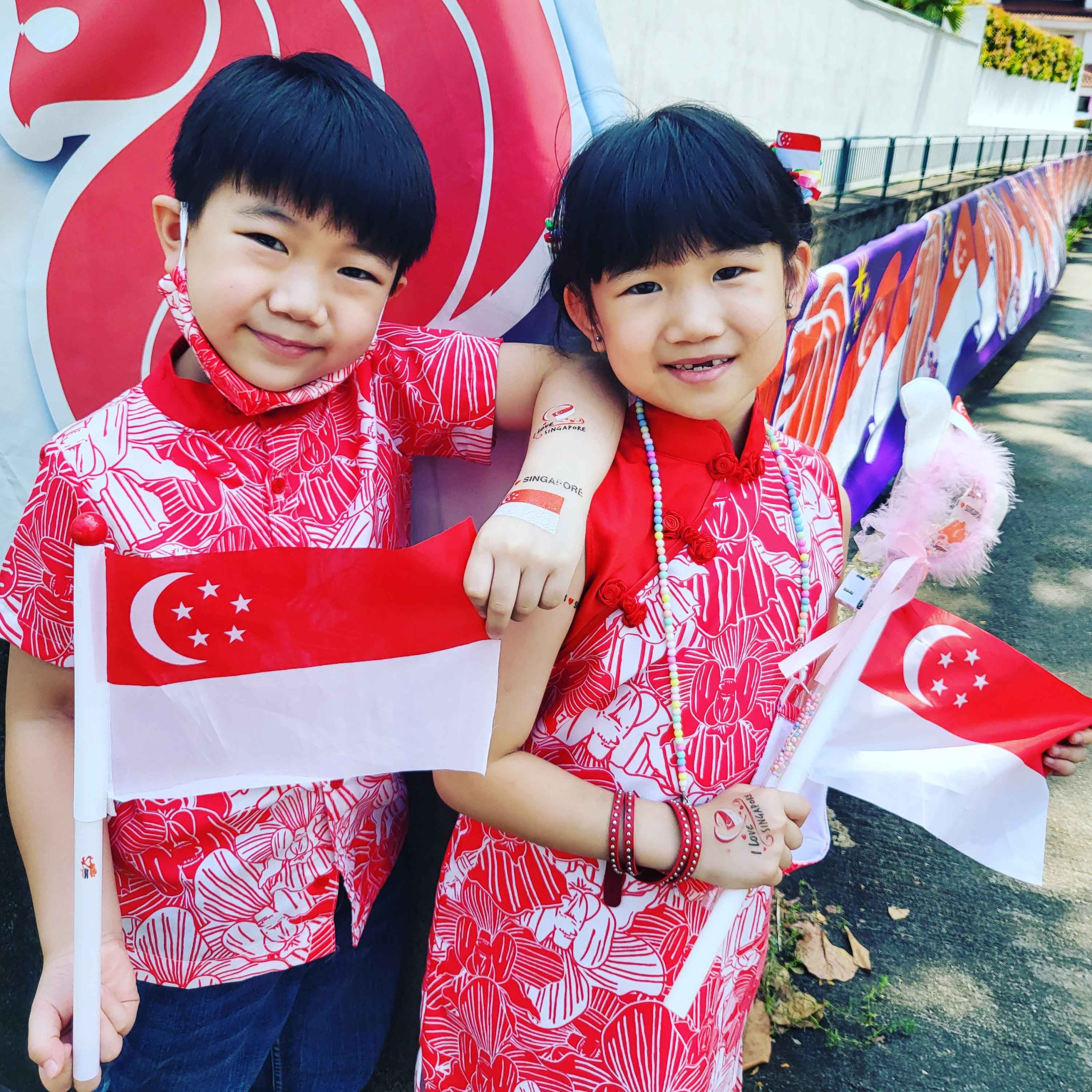 Keat Hong residents Aadon, 7, and Aadelynn, 6 decked in their patriotic outfits and next to a National Day banner outside their grandmother’s home in Bukit Gombak.